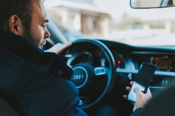 Man driving car on his phone.