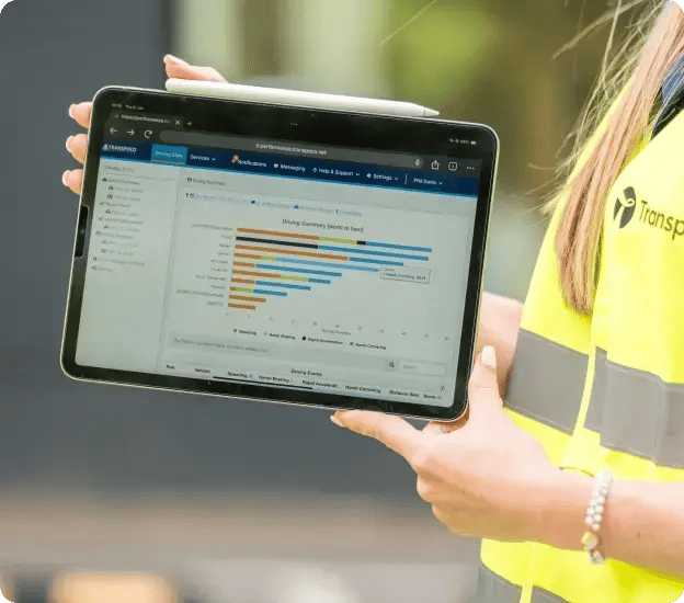 Transpoco employee in a high-vis jacket holding a tablet showing data