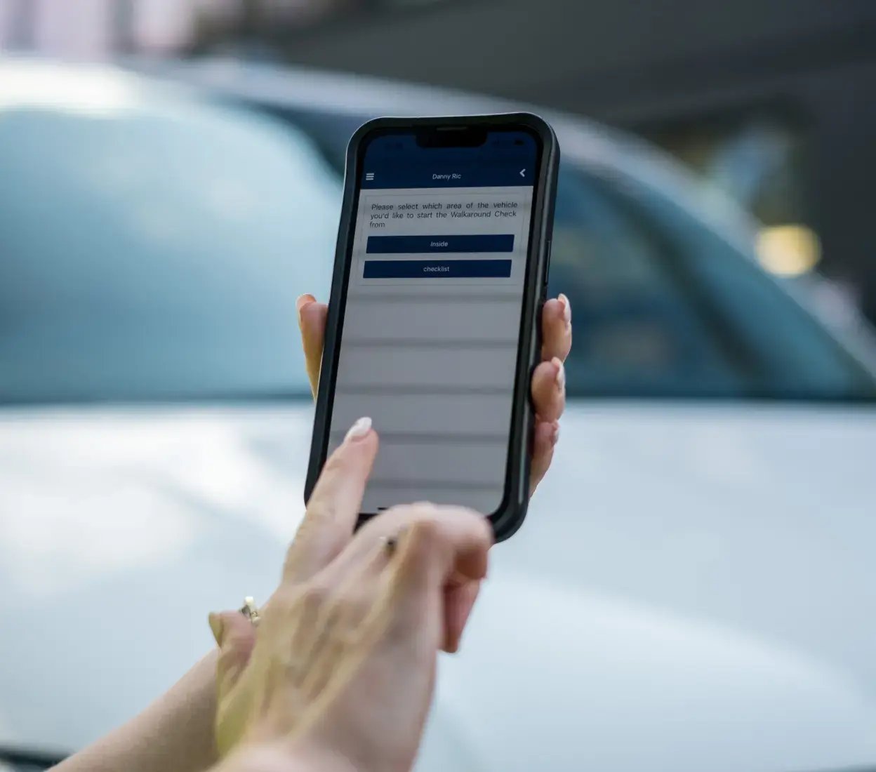 Close up of a person reviewing vehicle telematics data on a smartphone