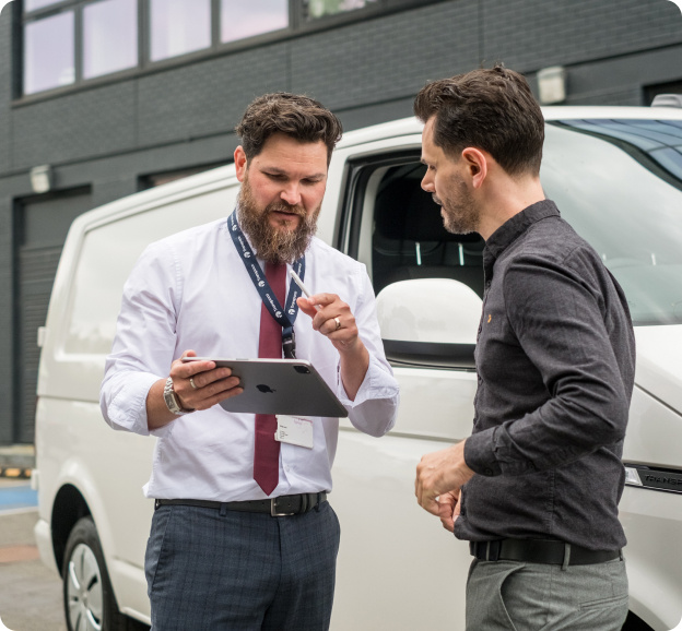 Transpoco employee in a light purple shirt reviewing data on a tablet with a driver