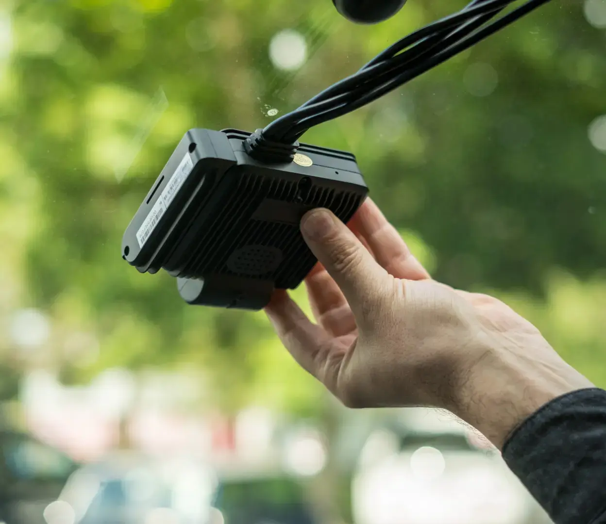 Close up of a windscreen as a driver installs a Transpoco AI-connected camera