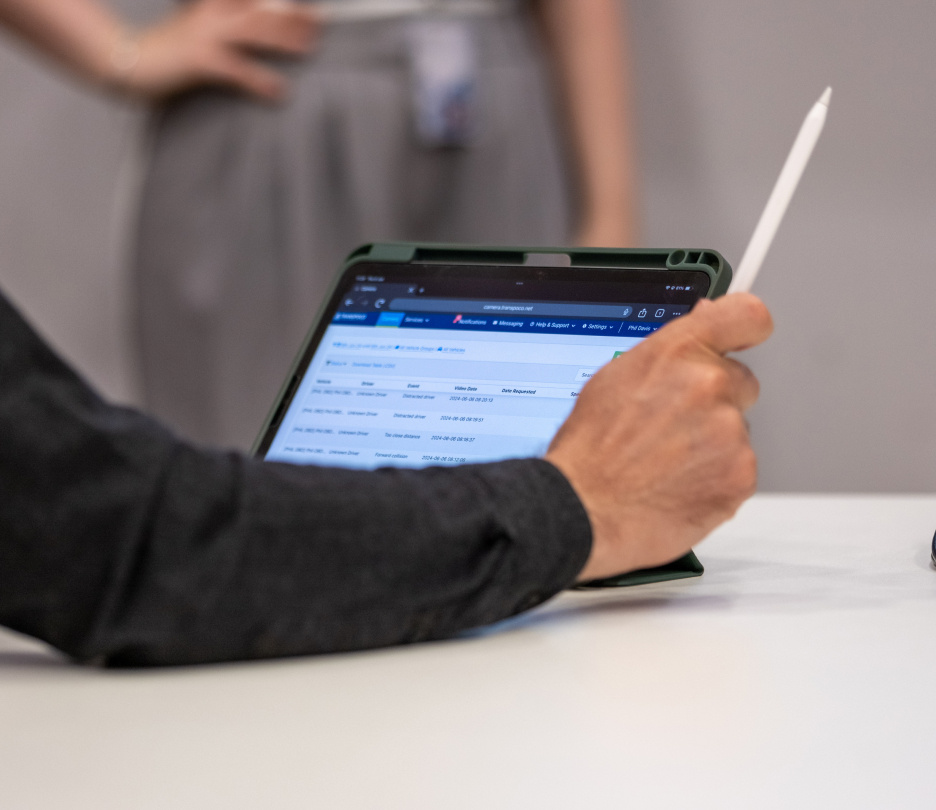 Person holding a stylus, looking at telematics data on a tablet