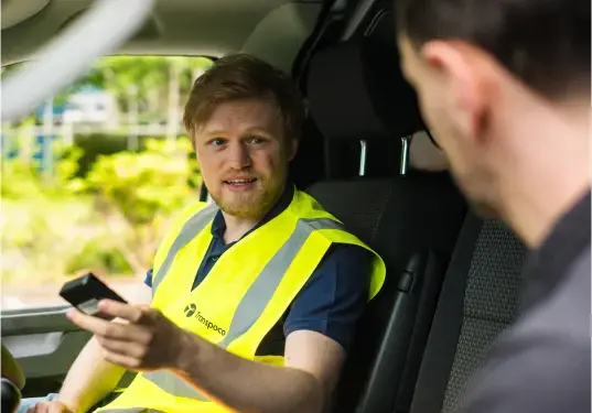 Transpoco employee sitting in the driver's seat of a van, talking to a driver